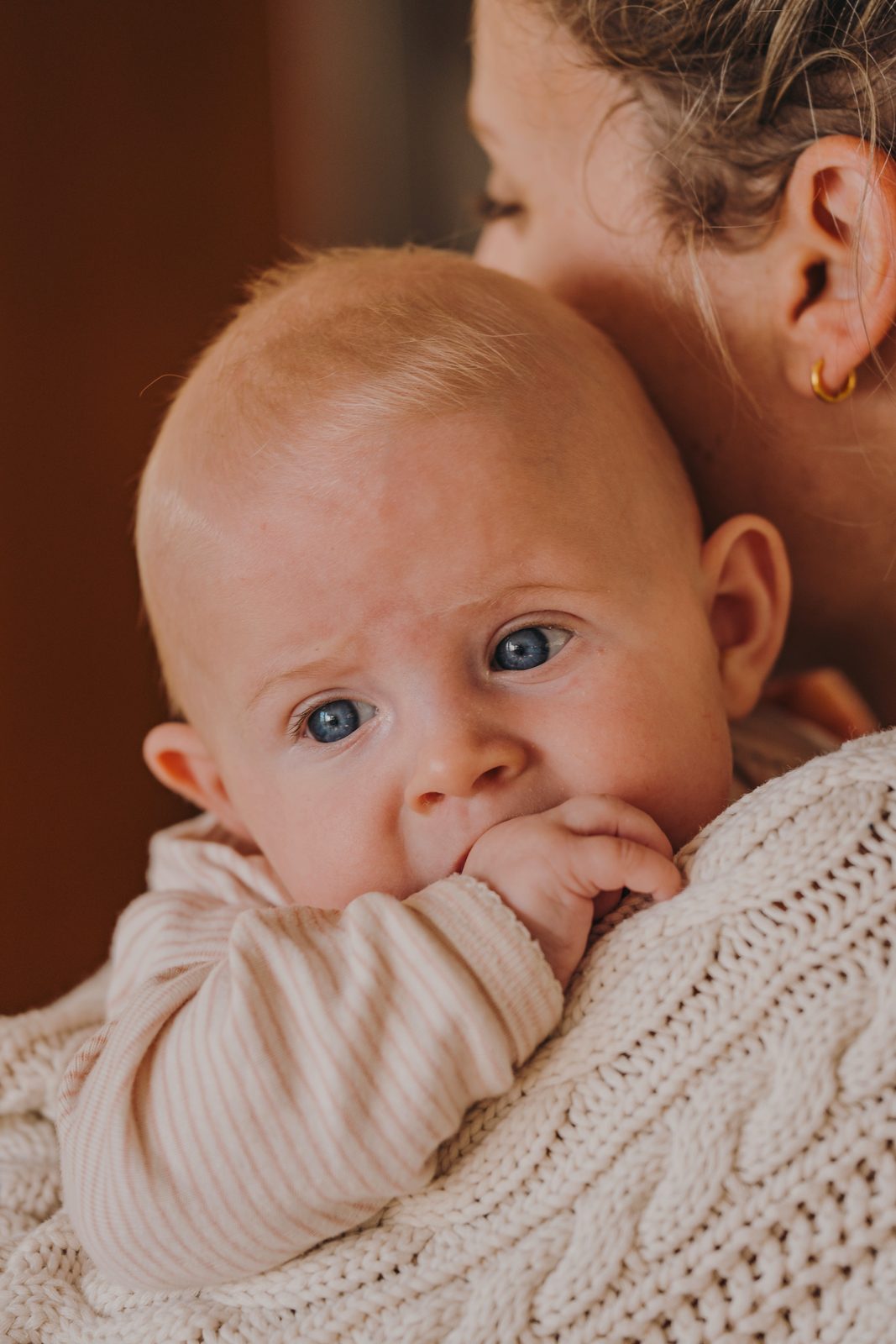 An infant held close over a shoulder
