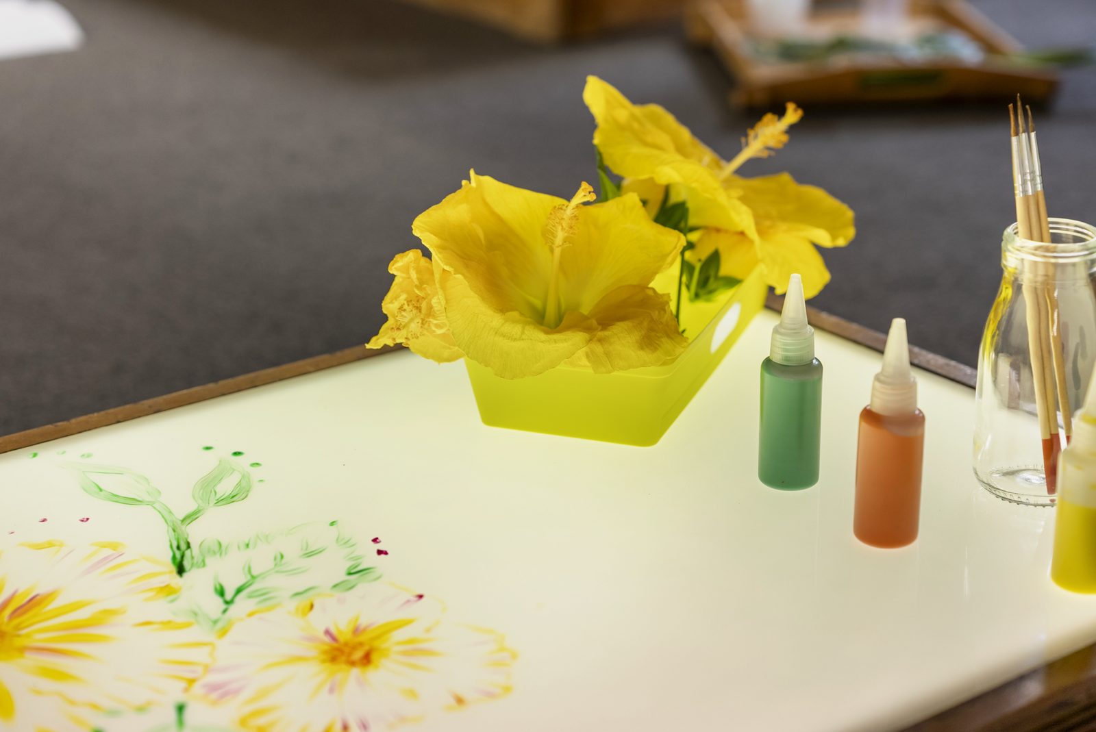 Hibiscus flowers and paint jars on the light table