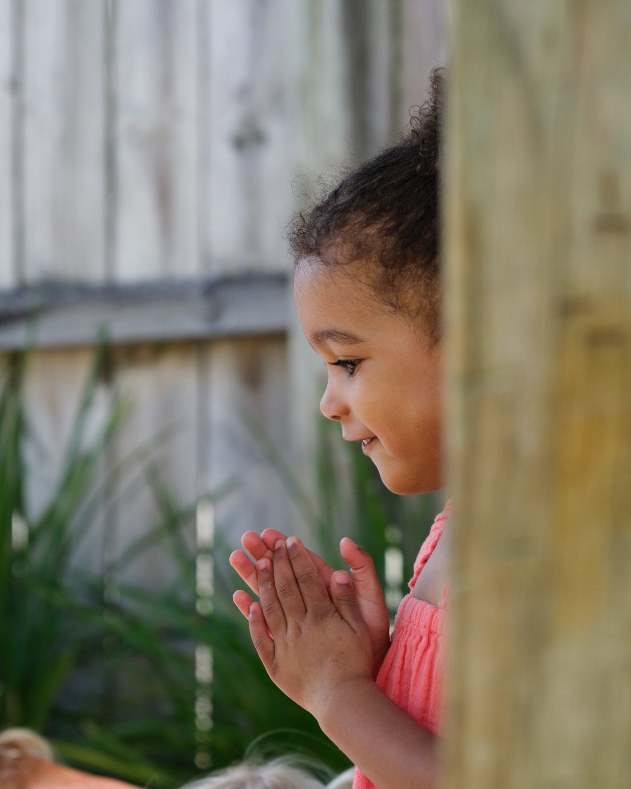 A child in a quiet moment of her own in the garden