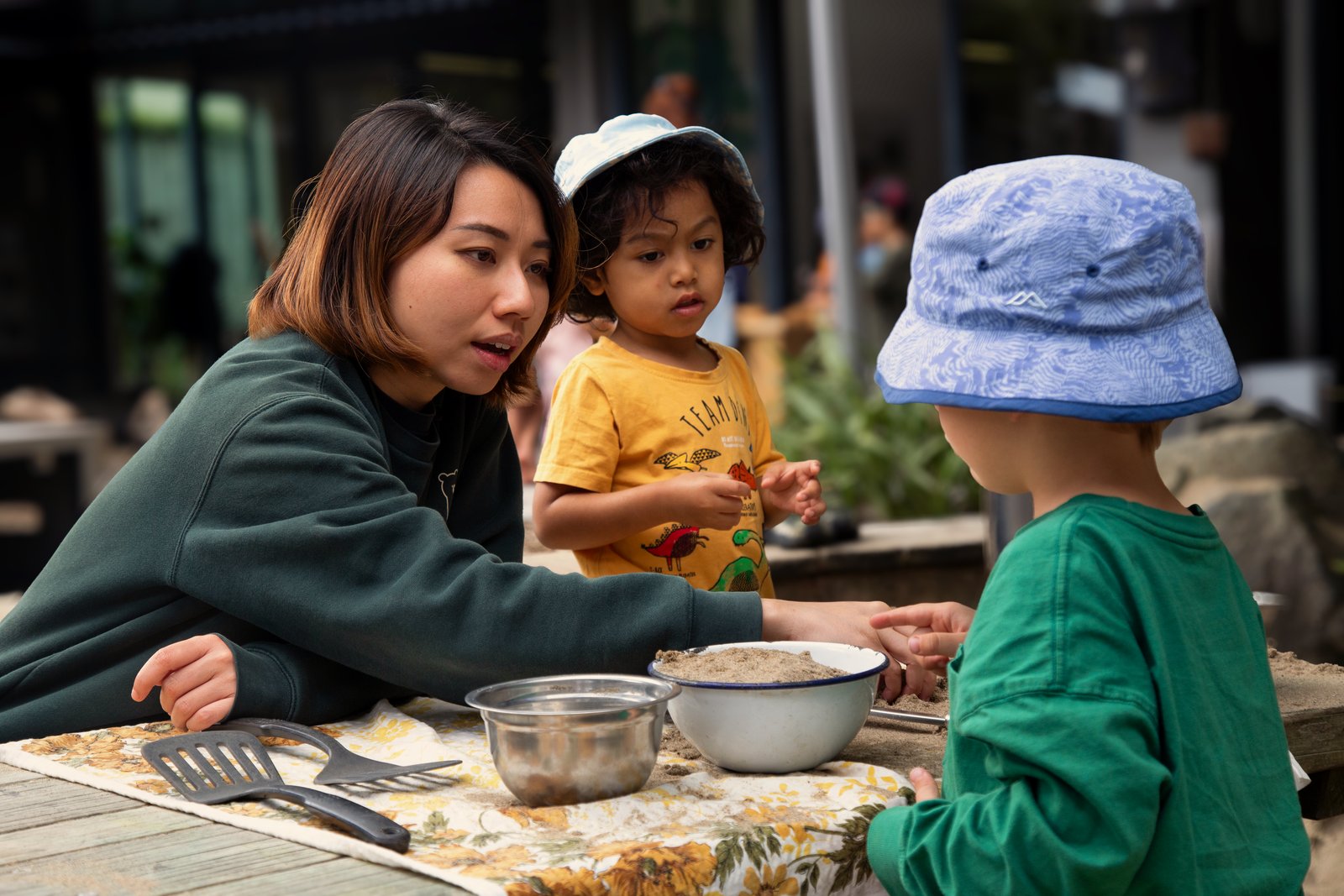 A teacher and children at the sand kitchen at Bear Park Remuera