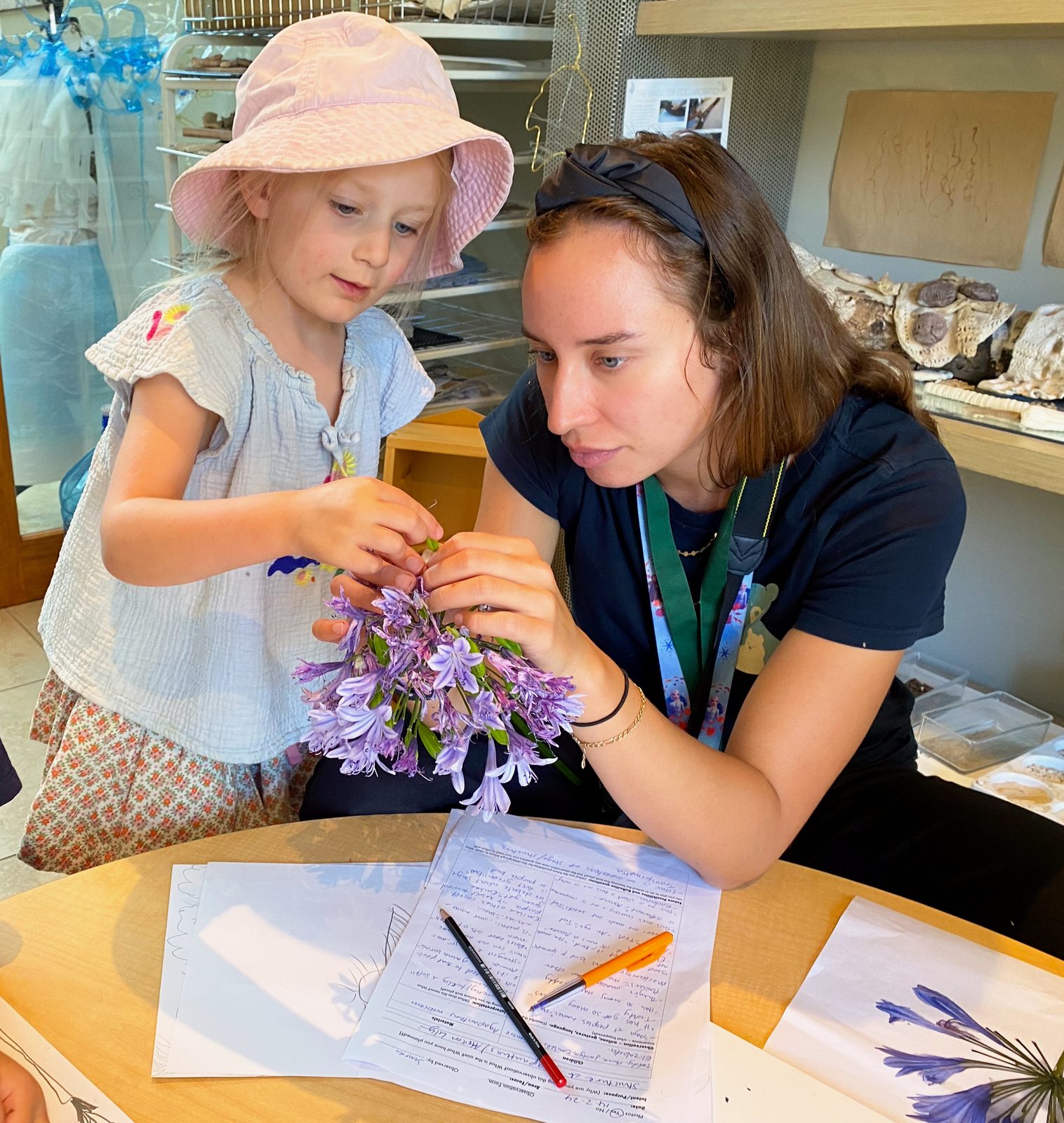 A Bear Park teacher and child studying agapanthus flowers together in the atelier